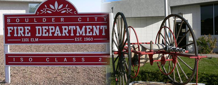 An antique fire hose apparatus next to the Boulder City Fire Department sign